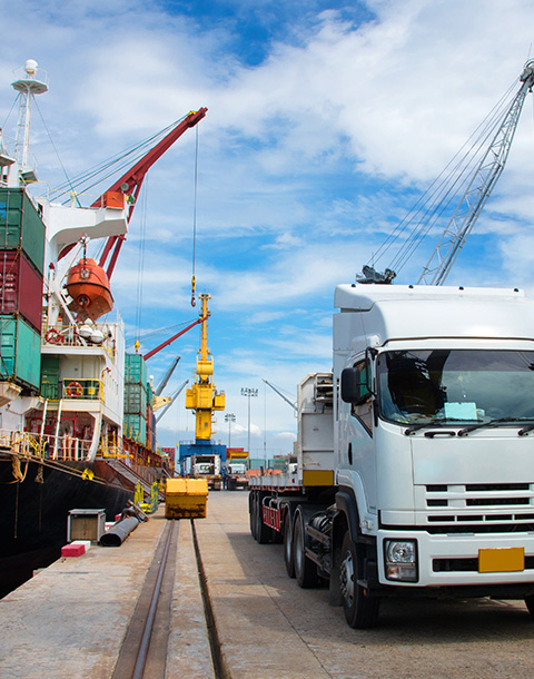 cargo ship and truck at port with cranes and blue sky showing freight transportation and logistics for 12 containers